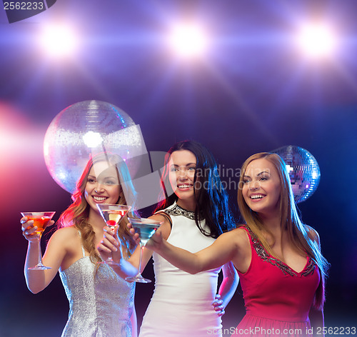 Image of three smiling women with cocktails and disco ball