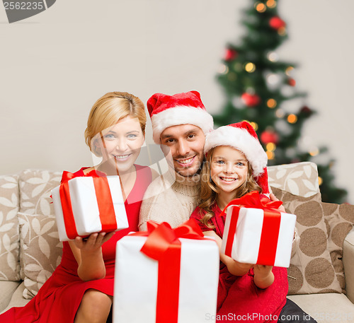 Image of smiling family giving many gift boxes