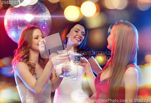 Image of three smiling women with cocktails and disco ball