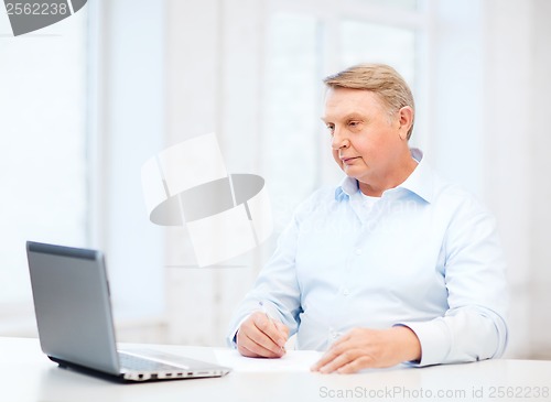 Image of old man filling a form at home