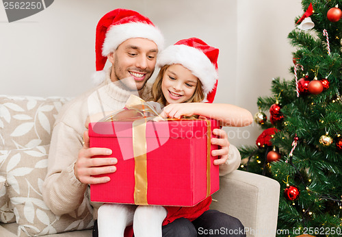 Image of smiling father and daughter opening gift box