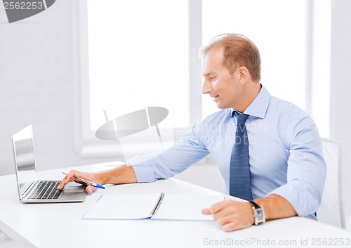 Image of smiling businessman working in office