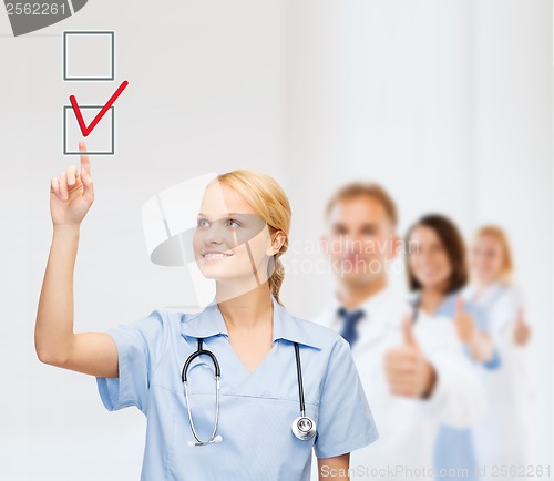 Image of doctor or nurse drawning checkmark into checkbox
