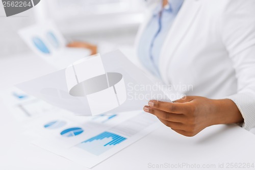 Image of woman hands with charts and papers