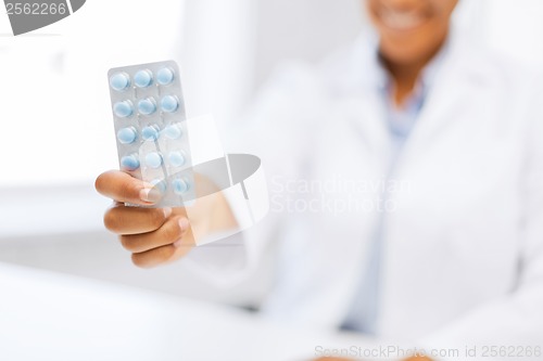 Image of female doctor hand giving pack of pills