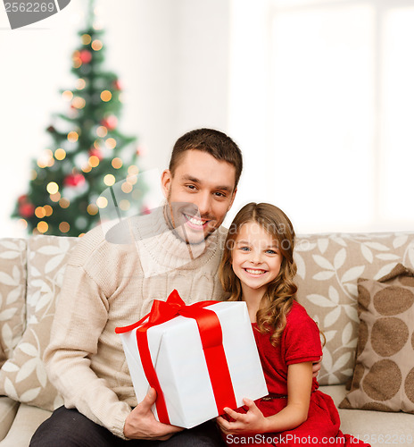 Image of smiling father and daughter holding gift box