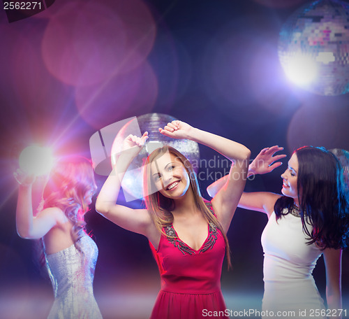 Image of three smiling women dancing in the club