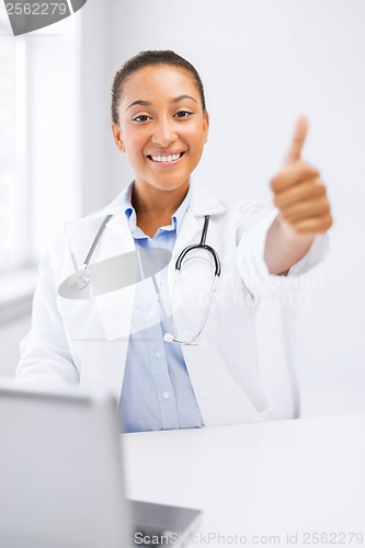 Image of female doctor with laptop showing thumbs up