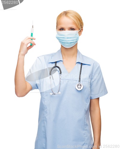 Image of female doctor or nurse in mask holding syringe