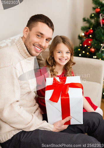 Image of smiling father and daughter holding gift box