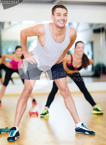 Image of smiling male trainer working out in the gym
