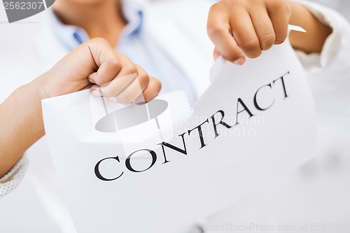 Image of woman hands tearing contract paper