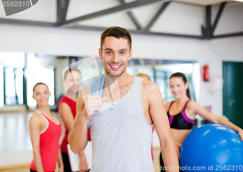 Image of smiling man standing in front of the group in gym