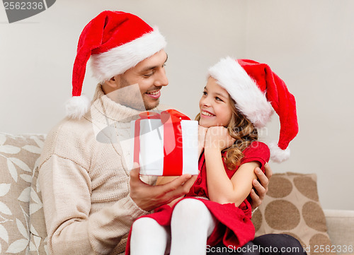 Image of smiling father giving daughter gift box