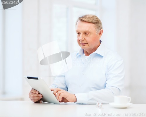 Image of old man with tablet pc computer at home