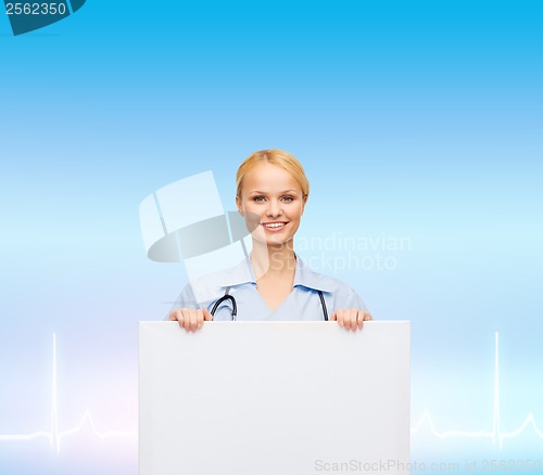 Image of smiling female doctor or nurse with blank board