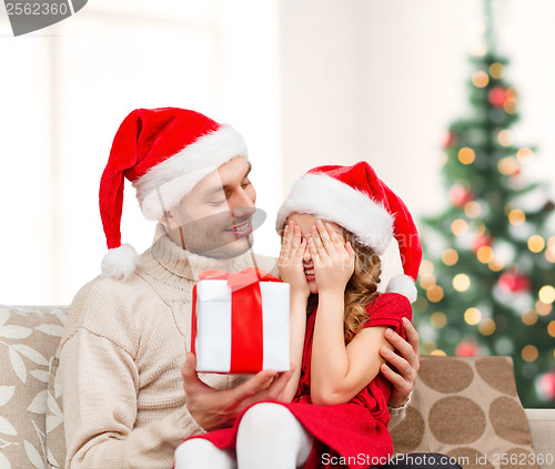 Image of smiling daughter waiting for a present from father