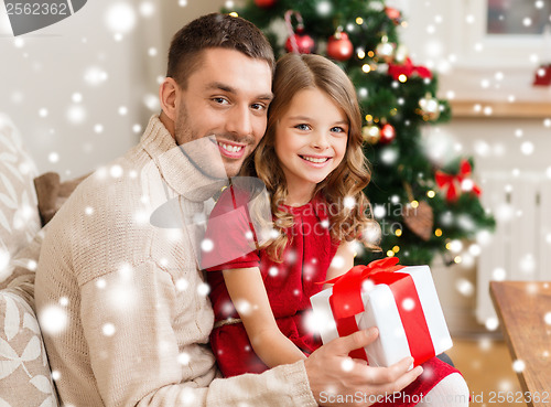 Image of smiling father and daughter holding gift box