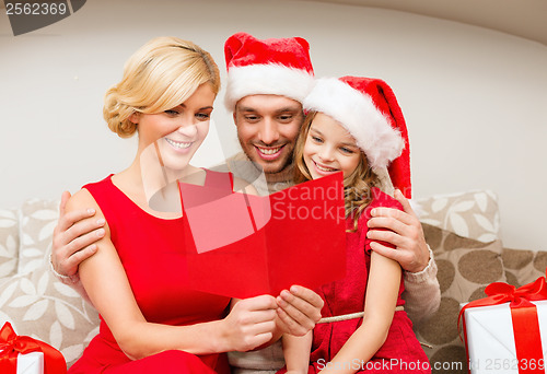 Image of smiling family reading postcard