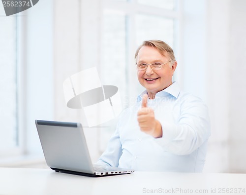 Image of old man with laptop computer showing thumbs up