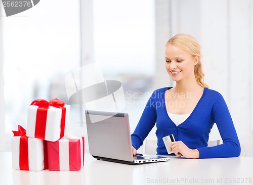 Image of woman with gifts, laptop computer and credit card