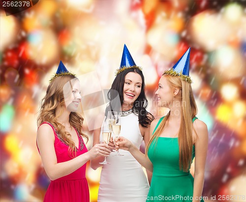 Image of three women wearing hats with champagne glasses