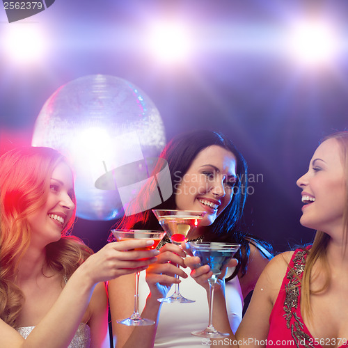 Image of three smiling women with cocktails and disco ball