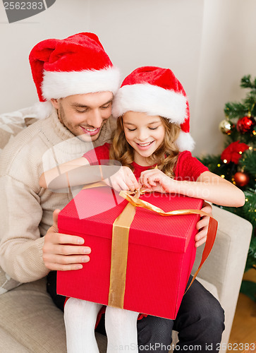 Image of smiling father and daughter opening gift box