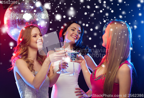 Image of three smiling women with cocktails and disco ball