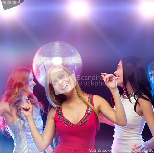 Image of three smiling women dancing in the club
