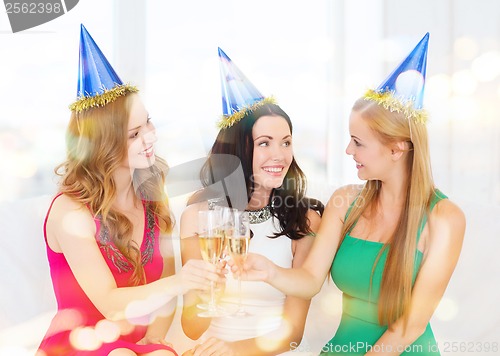 Image of three women wearing hats with champagne glasses