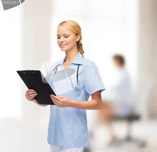 Image of smiling female doctor or nurse with clipboard