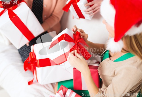 Image of three women holding many gift boxes