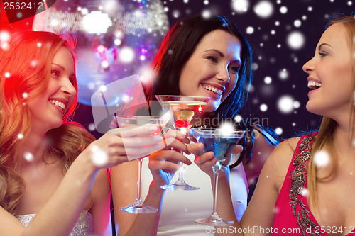 Image of three smiling women with cocktails and disco ball