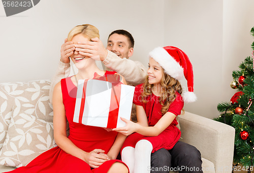 Image of father and daughter surprise mother with gift box