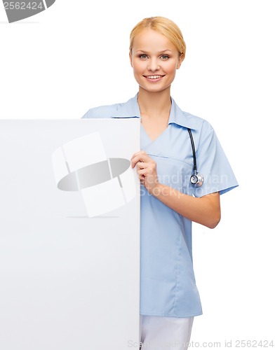 Image of smiling female doctor or nurse with blank board