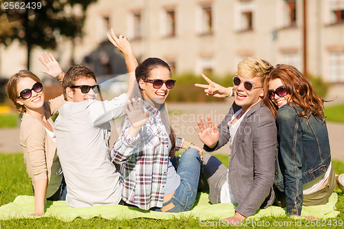 Image of group of students or teenagers waving hands