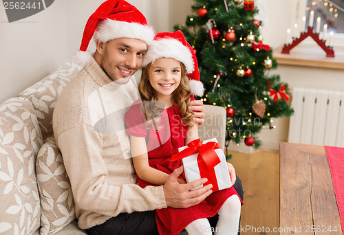 Image of smiling father and daughter holding gift box