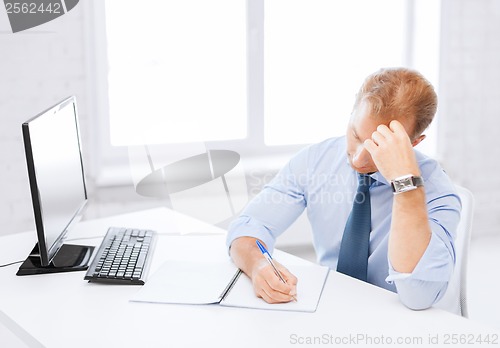 Image of businessman with notebook and computer