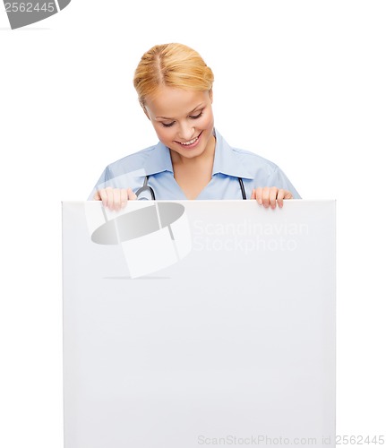 Image of smiling female doctor or nurse with blank board
