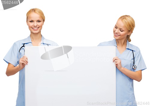 Image of smiling female doctor or nurse with blank board