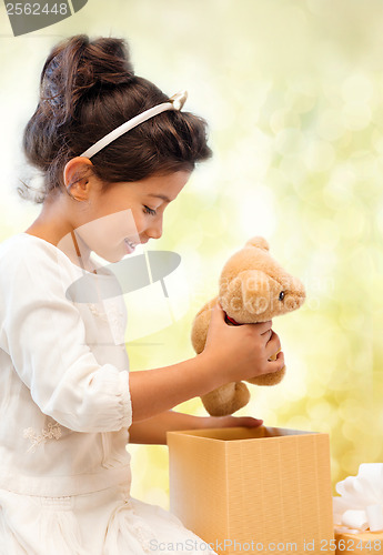 Image of happy child girl with gift box and teddy bear