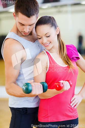 Image of two smiling people working out with dumbbells