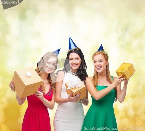 Image of three smiling women in blue hats with gift boxes