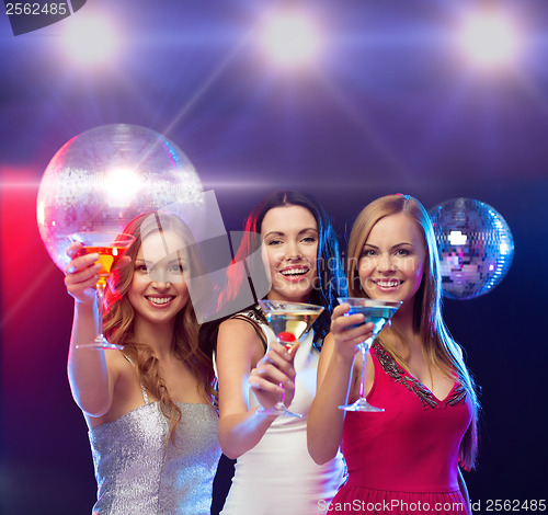 Image of three smiling women with cocktails and disco ball