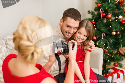 Image of mother taking picture of father and daughter