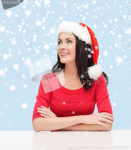 Image of surprised woman in santa helper hat looking up