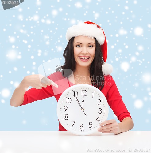 Image of woman in santa helper hat with clock showing 12