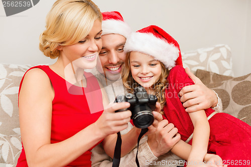 Image of family in santa helper hats looking at pictires