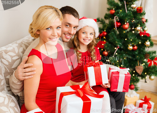 Image of smiling family holding many gift boxes